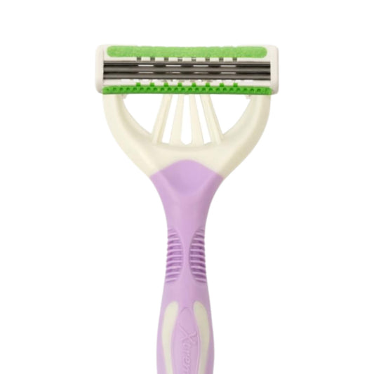A double-sided manual body razor with a lavender purple handle, cream plastic frame, and green and white protective trim on the blades, shown against a plain white background.