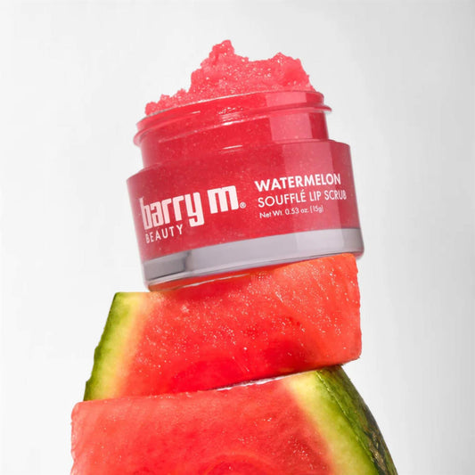 Barry M Watermelon Soufflé Lip Scrub 15g jar with red sugar scrub texture stacked on fresh watermelon slices