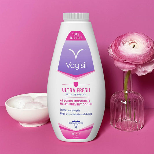 Vagisil Ultra Fresh Intimate Powder 100g 100 percent talc-free moisture absorber on a pink background with a ranunculus flower