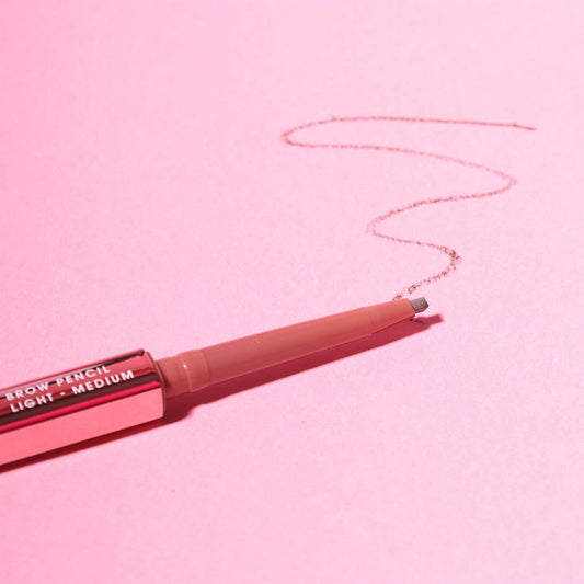 Brow pencil on a pink background with a line drawn by it