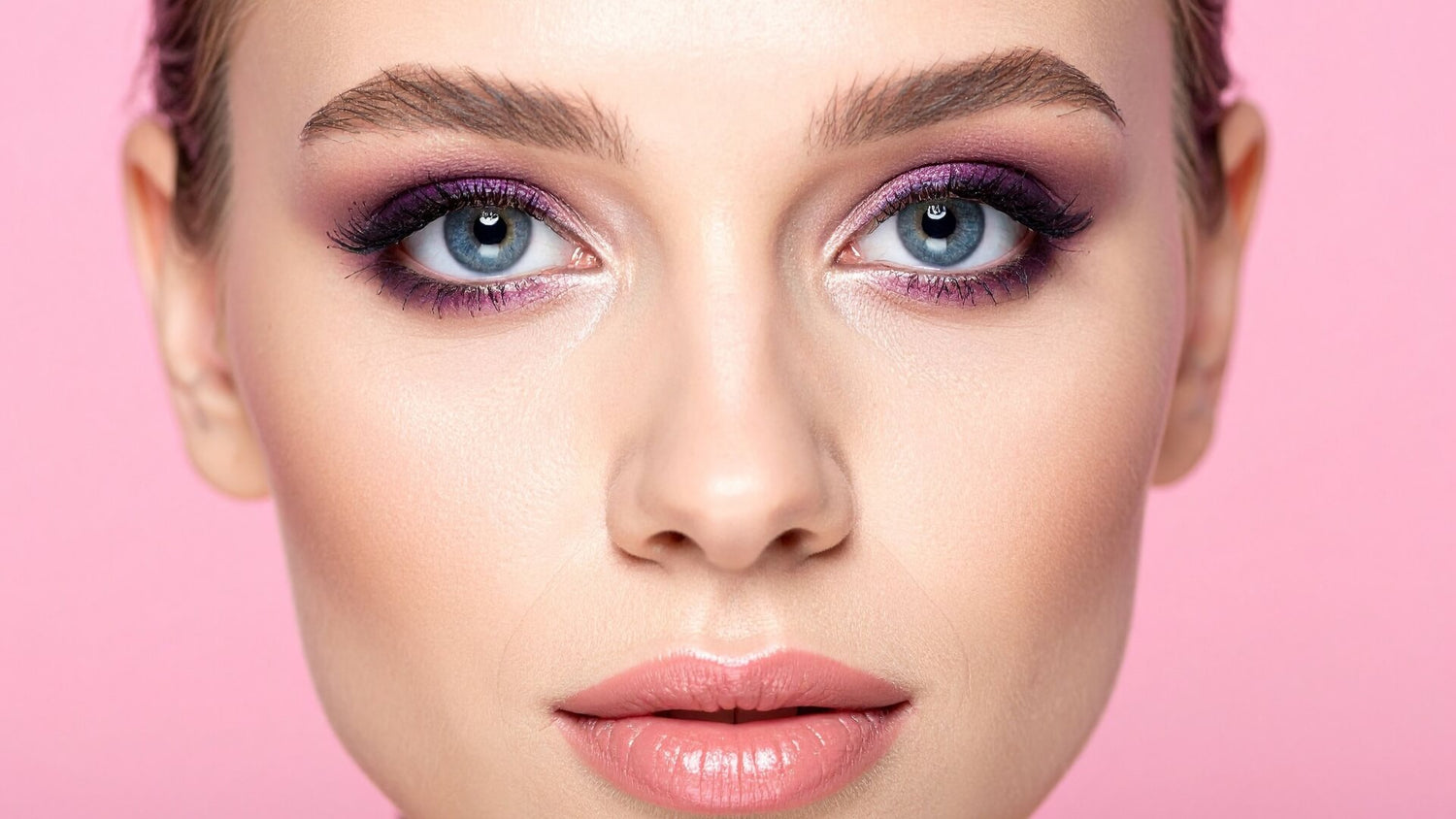 Close up of professional eye makeup with purple eyeshadow and soft pink lips for a glamorous makeup collection banner