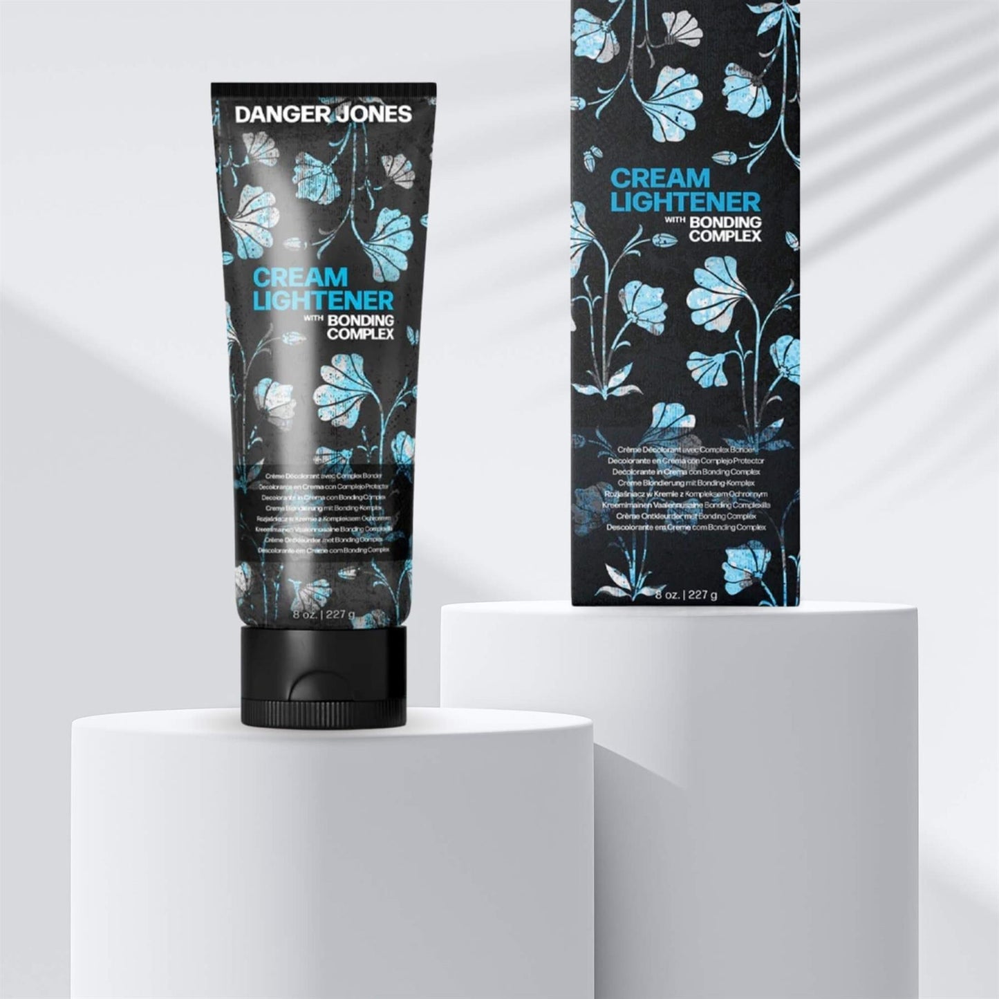 Danger Jones Cream Lightener 227g tube and box with Bonding Complex displayed on white pedestals