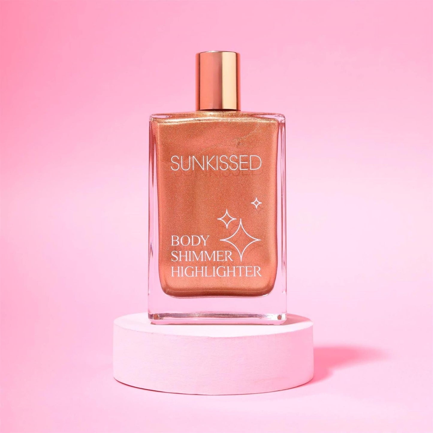 Sunkissed Body Shimmer Highlighter 100ml glass bottle displayed on a pink pedestal against a vibrant pink background